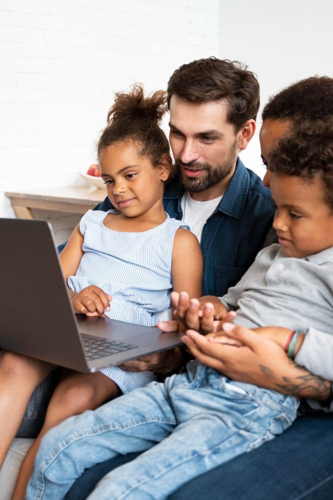 parents with children watching laptop